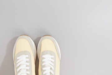 classic light color sneakers on grey background