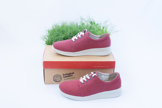 Fryazino, RUSSIA - April 20, 2022: Orthopedic shoes of the German manufacturer Berkemann. Burgundy sneakers made from recycled textiles. Caring for the environment. Sneakers are on the box