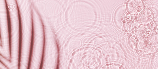 Water background. Pink aqua texture, surface of ripples, transparent palm leaf shadows and...