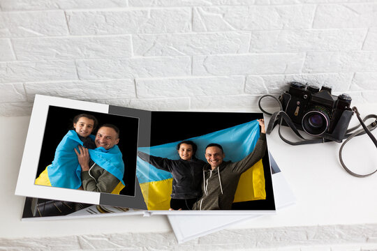 on white table open photobook from photo shoot of family with ukraine flag