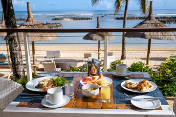 breakfast at a beach with palm trees and a pool in Mauritius, a tropical setting with breakfast.