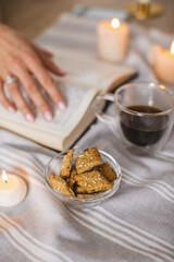 Still life with a Cup of coffee, cookies, candles and a book. The atmosphere of a cozy morning Breakfast at home or in a cafe.