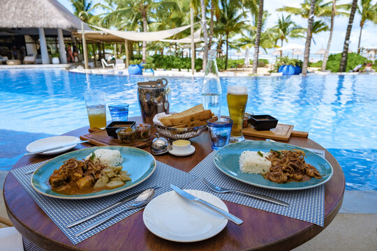 Lunch By A Swimming Pool During A Vacation In Mauritius, A Tropical Setting With Lunch Drinks And Curry By A Pool. 