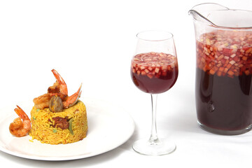 Traditional paella rice from Valencia Spain, made with saffron shellfish, shrimp and vegetables served on a white plate accompanied by red wine and a glass of clericot on a white background
