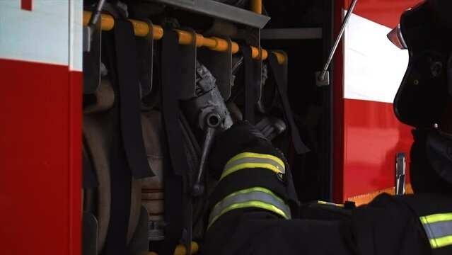 Rescue Team of Firefighters Arrive at the Crash, Catastrophe, Fire Site on their Fire Engine. Firemen Grab their Equipment, Prepare Fire Hoses and Gear from Fire Truck, Rush to Help Injured People.