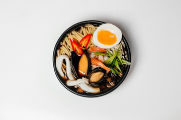 Ramen, noodle and egg soup, Asian food, Ramen in a black round plate, Ramen with chicken and mussels