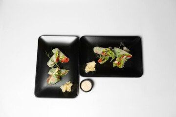 fresh vegetarian rolls with vegetables on a black plate beautifully laid out. Asian cuisine