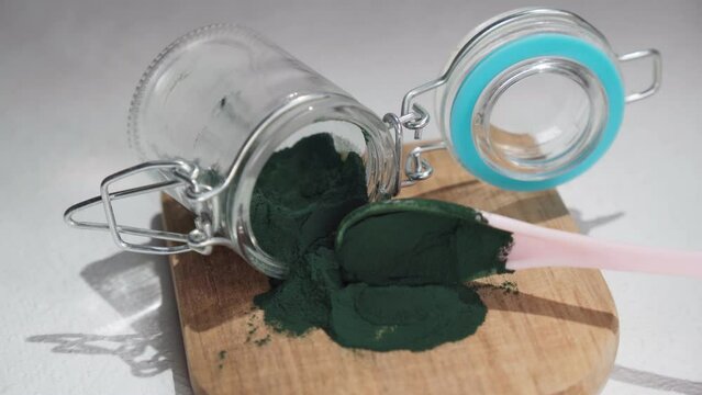 Green spirulina, spirulina powder with spoon. Useful habits, self care and healthy lifestyle.