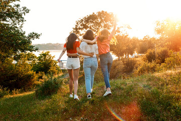 Summer Camp, Summer Classes, Friends University. Three cheerful girls friends dance and jump on...