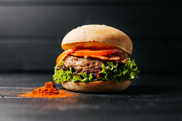 hamburger decorated
 paprika on a black wooden background composition