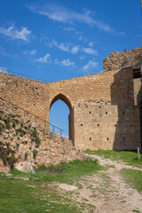 Camino hacia el arco y muros de un castillo en ruinas