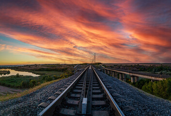 Sunset panorama of railway bridge and industrial city