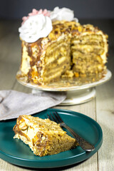 Birthday layer cake with chocolate pieces and hazelnuts and almonds on green plate