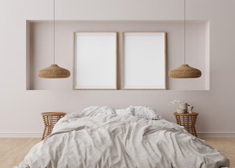 Two empty vertical picture frames on light gray wall in modern bedroom. Mock up interior in scandinavian, boho style. Free space for picture, poster. Bed, rattan lamps. 3D rendering.