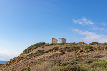 Fototapeta na wymiar The Temple of Poseidon on a rock rises above the blue sea. Europe, Greece, Cape Sounion, Aegean Sea