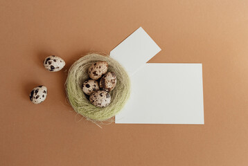 Quail eggs in a sisal nest on a pastel beige background. Easter decoration, egg minimalist design, modern design template. Happy Easter greeting card, top view.