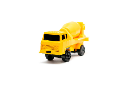 Colorful little mini yellow plastic concrete mixer, truck, lorry, car automobile toy isolated on white background mockup with copy space, toys for children, kids development, playing, childhood fun