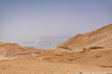 Widok krętej drogi poprzez pustynię Negev w Izraelu z Morzem Martwym w tle.