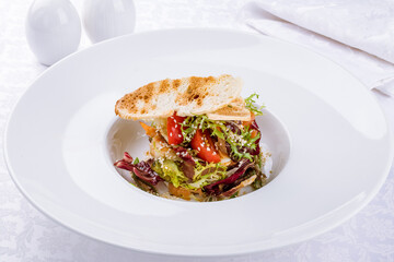 Salad with seafood and vegetables on a white plate
