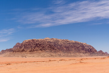 Fototapeta na wymiar Widok z pustyni Wadi Rum w Jordania. Pustynia, wzgórza z czerwonego piaskowca i błękitne niebo.