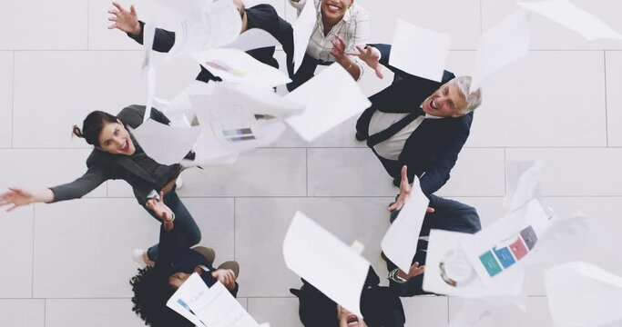Teamwork is the recipe for success. 4k footage of a group of businesspeople celebrating by throwing their paperwork in the air.