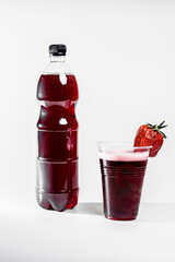Strawberry lemonade in a bottle. Strawberry lemonade in a glass with ice and decorated with fresh strawberries on a white background 