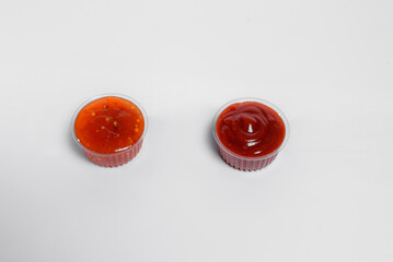 Ketchup and sauce in transparent boxes stands on a white background