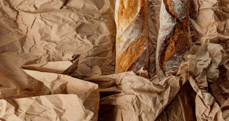 Wrapped two loaves in crumpled paper. Culinary background.