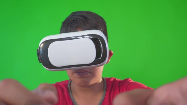 a boy playing game in virtual reality goggles on a Green Screen, Chroma Key.