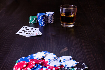 Poker game with pot of chips cards and a drink