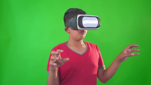 a boy playing game in virtual reality goggles on a Green Screen, Chroma Key.