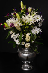 Colorful flower bouquet arrangement in vase isolated on black