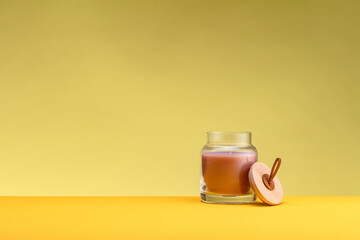Round decorative candlestick in a glass pot on a yellow background
