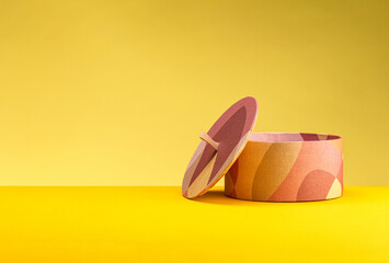 Round handmade box with lid on yellow background. The concept of minimalism. Poster for advertising. Place for text
