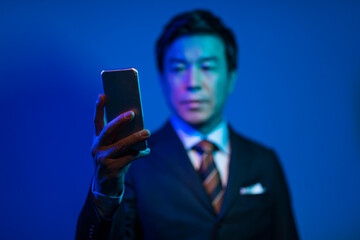 携帯電話を見る50代ビジネスマン