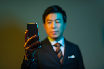 携帯電話を見る50代ビジネスマン