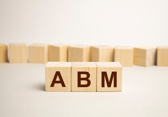 Businesswoman made word abm with wood building blocks.