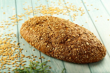 Top view- fresh baked multigrain brown bread on  a wooden kitchen table.