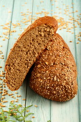 Homemade oven fresh multigrain brown crusted bread loaf on a rustic kitchen table background.