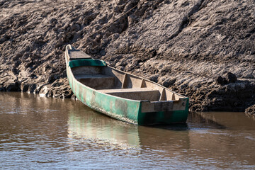 canoe on the shore of the calm river with sand
