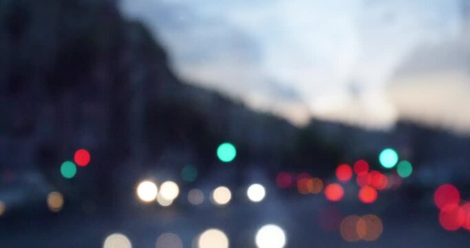 Abstract composite video of handheld camera motion - driving in the central street at dusk with defocused bokeh lights of the cars and streetlights - 4K DCI