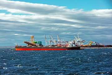 Fototapeta premium Ships under loading in the seaport in the city of Tsawwassen, stormy sea dramatic sky, overcast