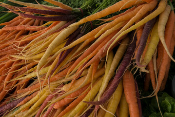 orange, yellow and purple carrots at a farmers market