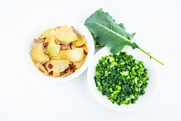Chinese home-cooked dishes with fried kohlrabi leaves and a plate of fried meat with kohlrabi head