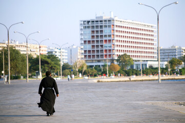 Priest walking at Thessaloniki seaside in Greece. Thessaloniki is the second largest city in Greece.