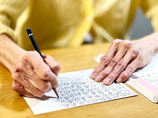 漢字の書き取りをする高齢者の手元 - obrazy, fototapety, plakaty
