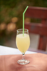 one glass of peach juice is on the table