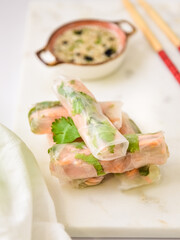 Raw spring rolls with salmon and vegetables  with soy sauce closeup food photography 