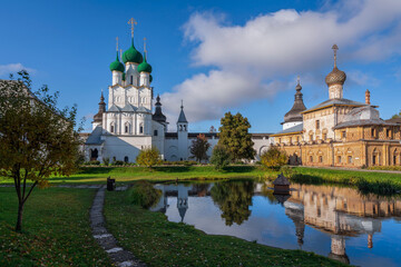 Fototapeta na wymiar View of the Church of St. John the Theologian and the Church of the Hodegetria on the right against the background of the pond in Vladychy Dvor, Rostov Kremlin, Yaroslavl region, Russia