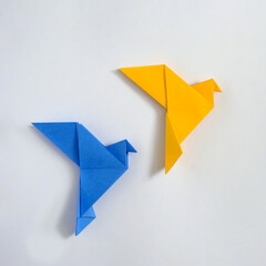 Japanese origami doves of peace yellow and blue concept of peace and help in the conflict in Ukraine and paper poster of hobby and entertainment. - obrazy, fototapety, plakaty